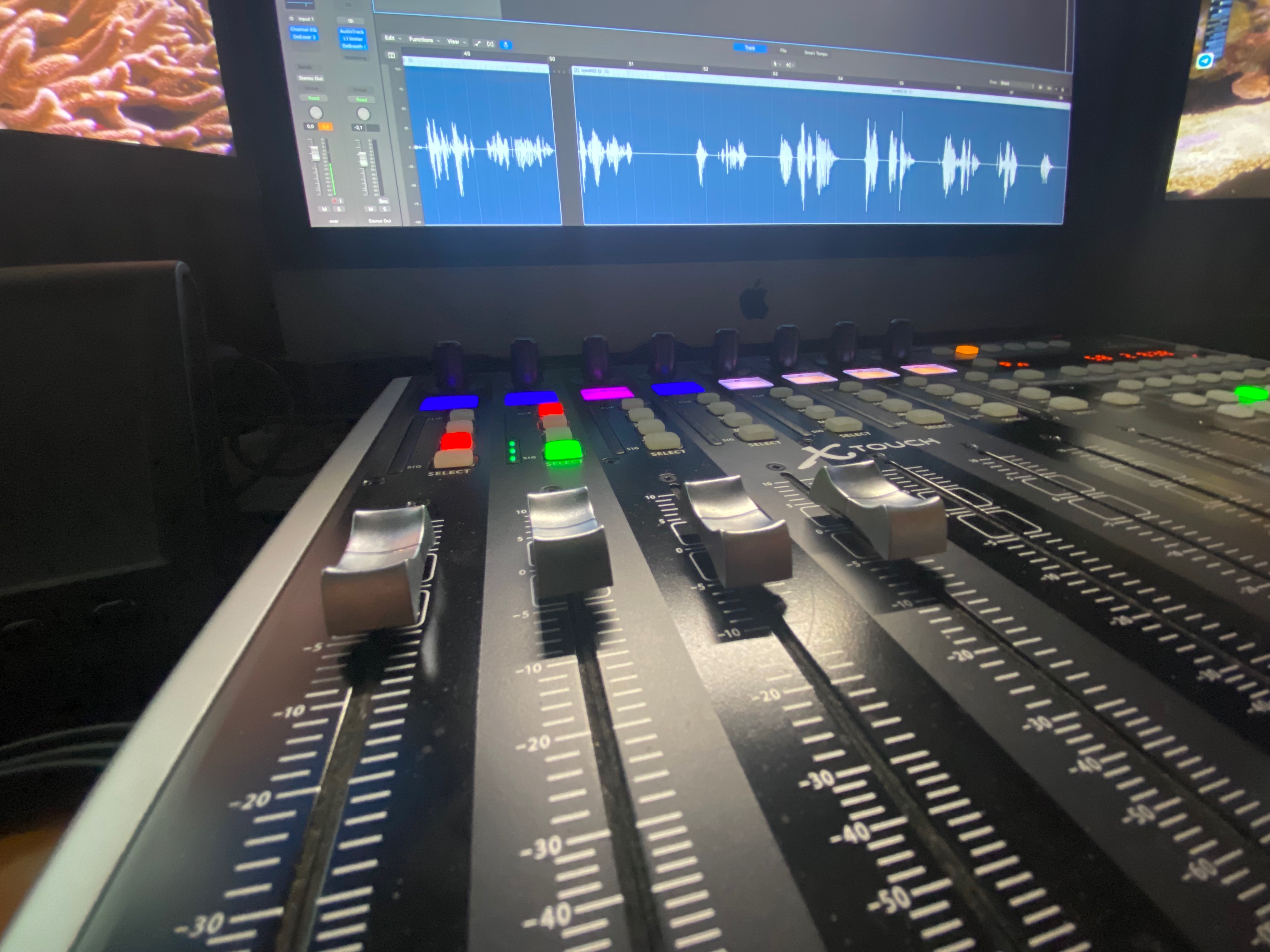 Behringer X-Touch Fader vor einem Logic Pro Bildschirm mit Voice-Over Wellenform — Post-Production im Studio.