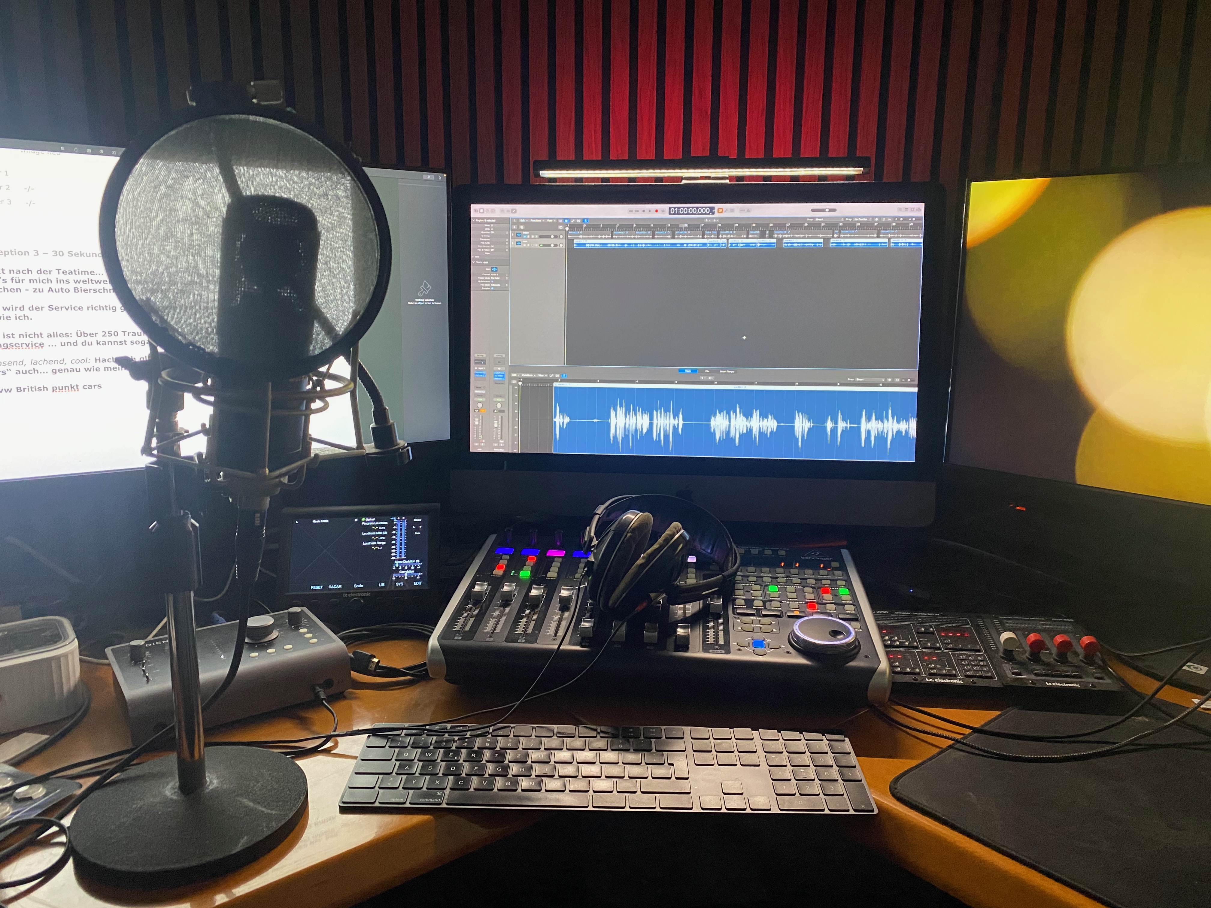 Sprecherplatz mit Neumann-Mikrofon, Popschutz, akustisch behandeltem Raum und Regie-Setup für Voice-Over-Aufnahmen.